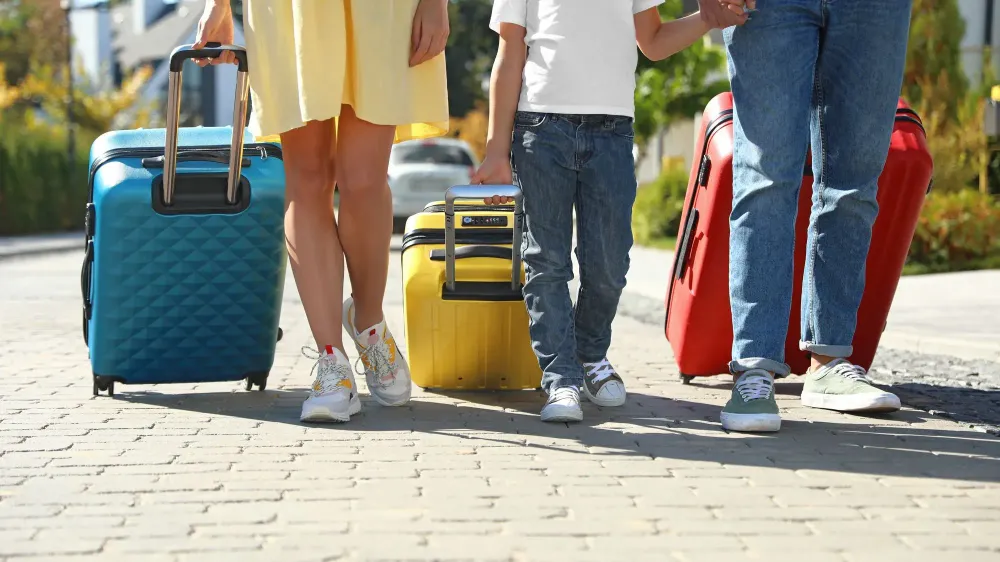 Close up of people rolling colorful luggage